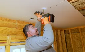 Contractor installing drywall ceiling during a room addition project in Dallas TX