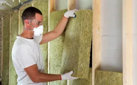 Professional contractor installing wall insulation during a room addition build in Dallas TX