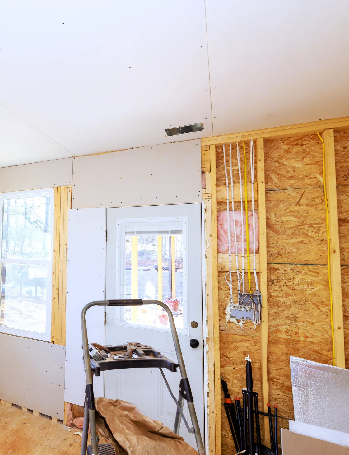 Room addition construction showing electrical wiring and drywall installation in a Dallas home