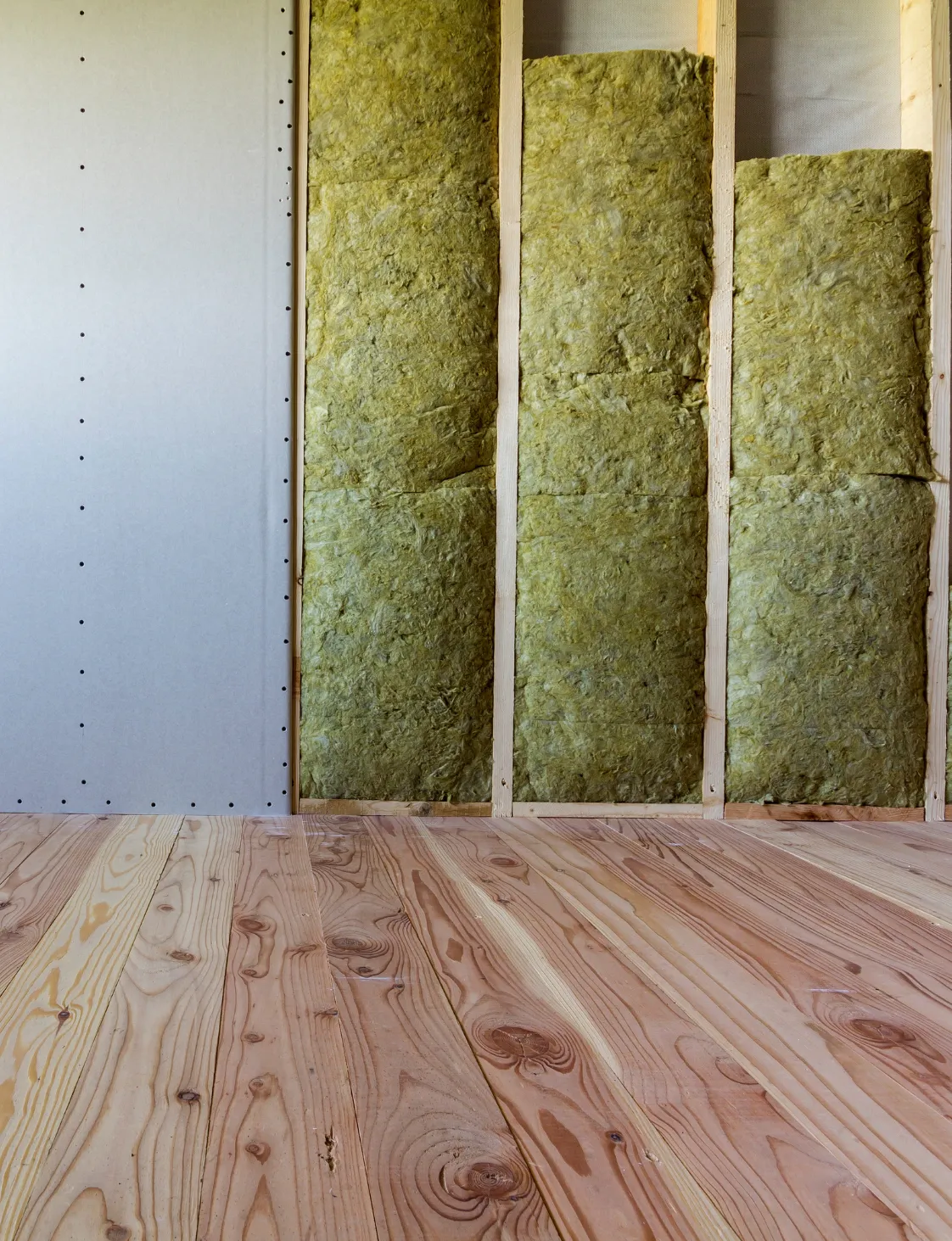 Close-up of insulated stud walls prepared for drywall in a Dallas room addition project
