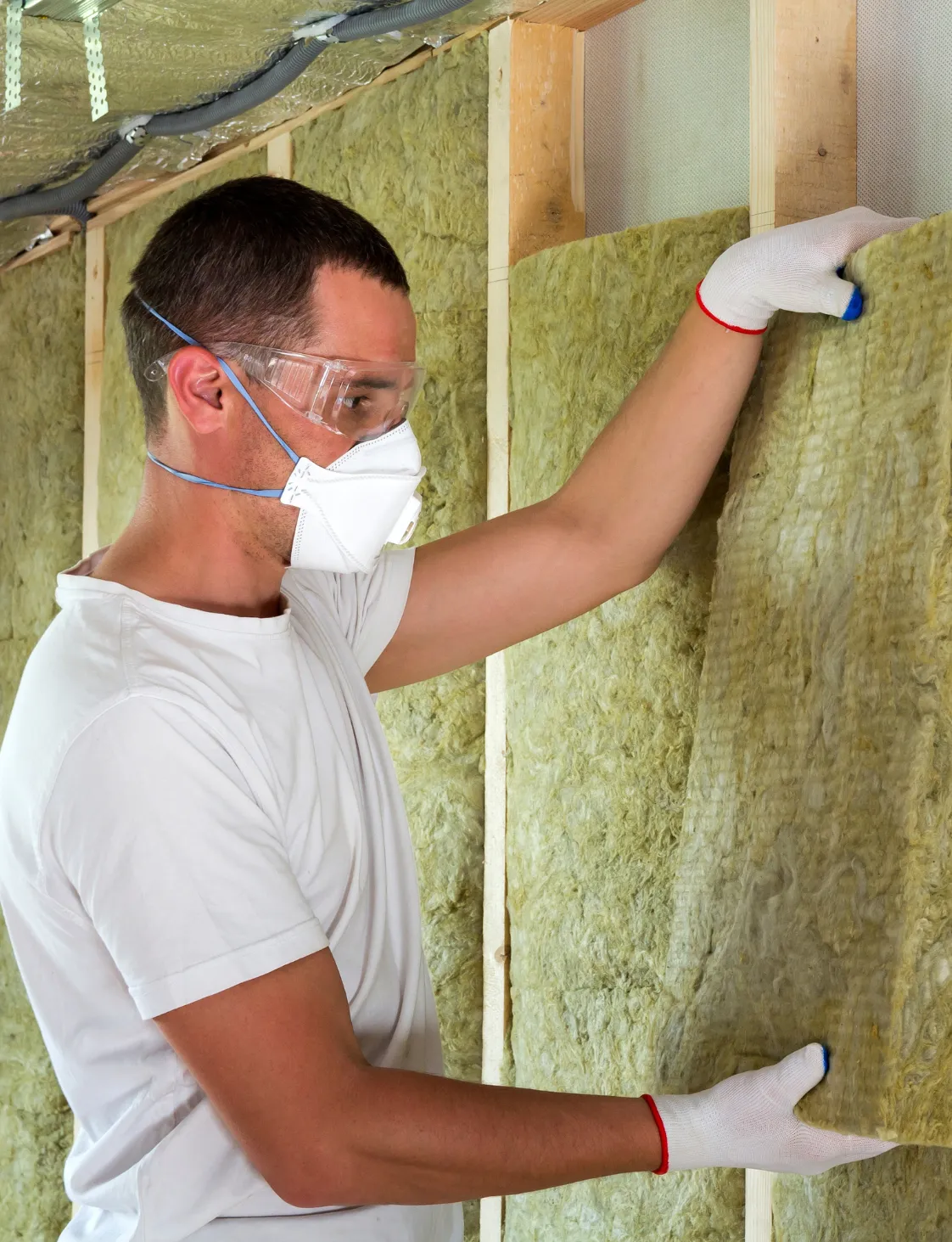 Professional contractor installing wall insulation during a room addition build in Dallas TX