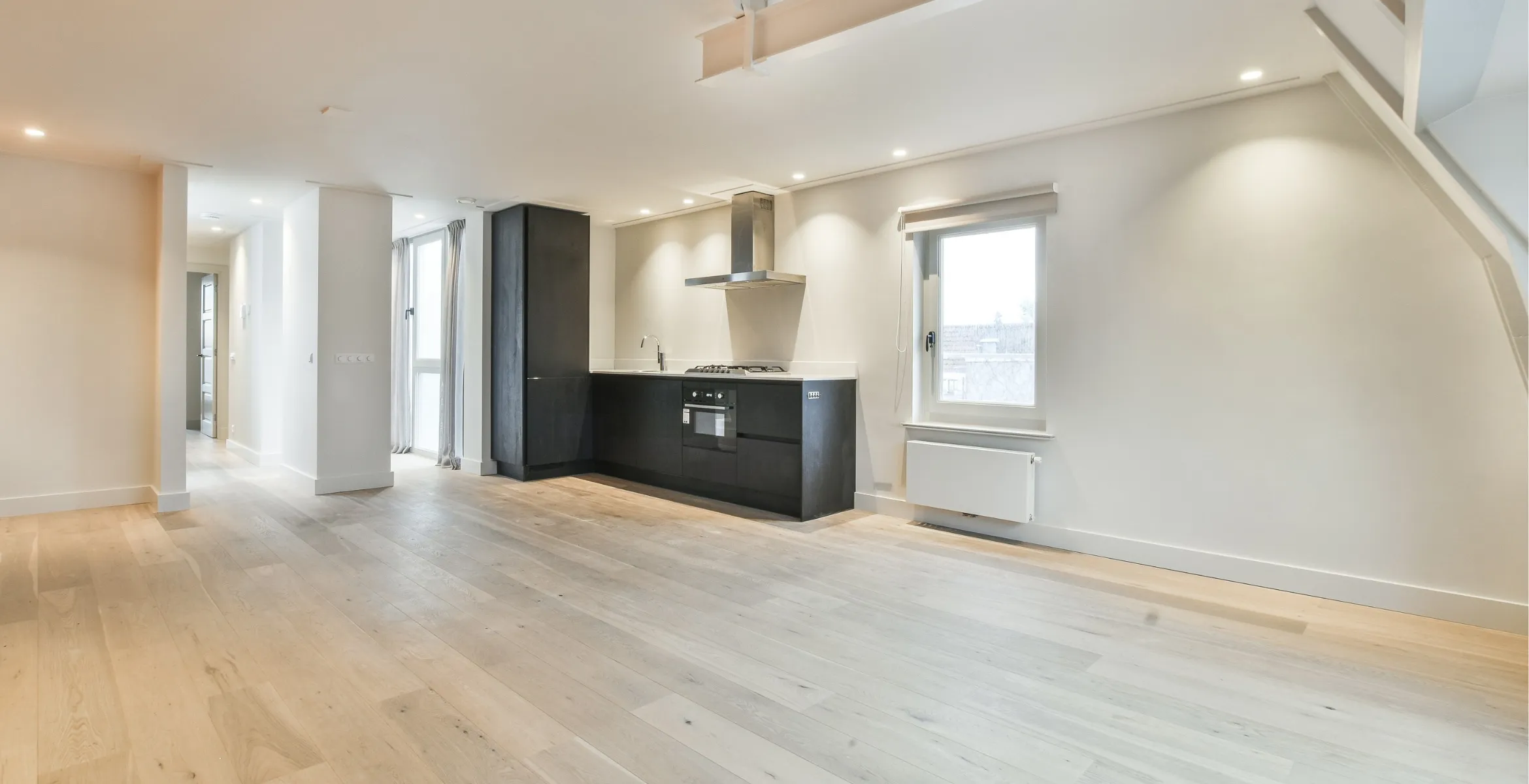 Modern open-plan kitchen extension in Dallas TX featuring light wood flooring, recessed ceiling lighting, and a spacious contemporary layout.