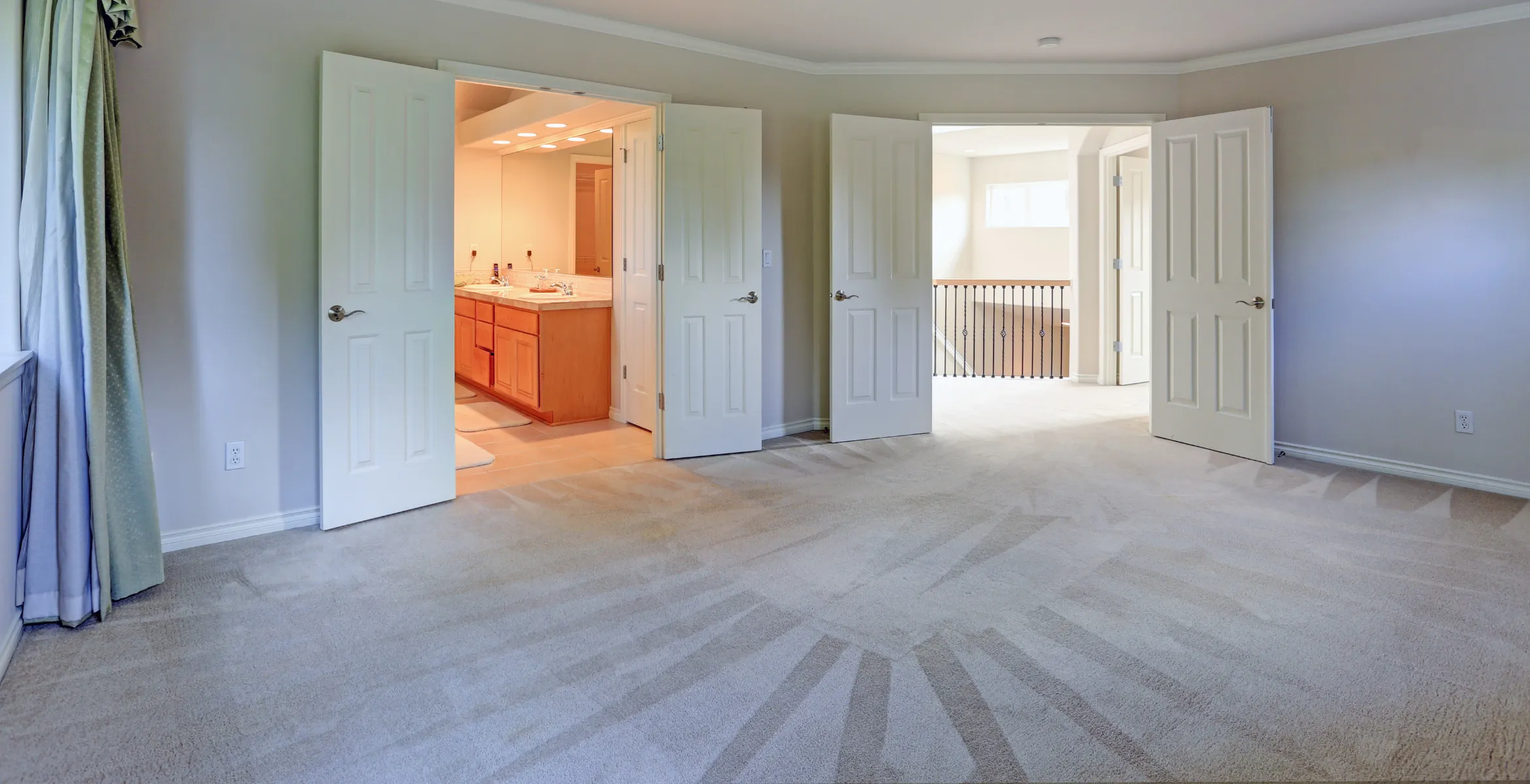 Second story home addition in Dallas TX featuring a spacious primary bedroom with ensuite bathroom access, neutral finishes, and seamless hallway connection.